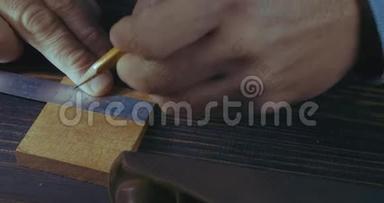 玛娜€™的手用铅笔和木梳标记木制细节的特写。 手工制作的工艺品