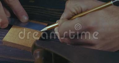 玛娜€™的手用铅笔和木梳标记木制细节的特写。 手工制作的工艺品