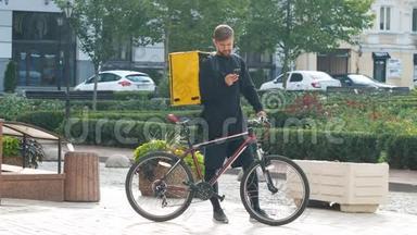 一个带着黄色包和自行车的<strong>快递</strong>员正在电话里寻找客户的地址。年轻的<strong>送</strong>货员