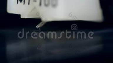 一张乙烯唱片用针刮在设备上播放音乐。