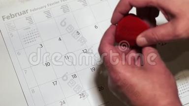 可爱的红心首饰盒，2月14日日历上的戒指，柔和色调。情人节提醒概念