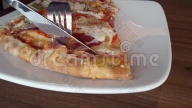 顾客用刀子切一块比萨饼。 咖啡馆里的快餐