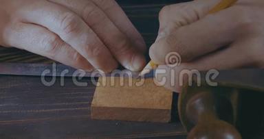 玛娜€™的手用铅笔和<strong>木梳</strong>标记木制细节的特写。 手工制作的工艺品