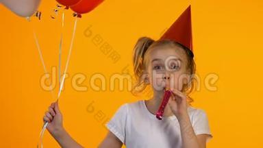 快乐的b日女孩带着气球使用派对鼓<strong>风机</strong>和笑在相机，有趣