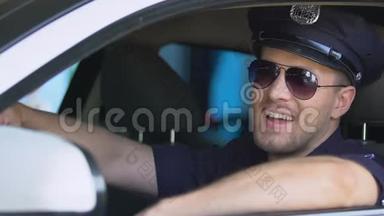 友好的<strong>警察</strong>戴上太阳镜，微笑着坐在巡逻车上