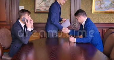 两个年轻的商人签了合同。 开始谈判，礼仪，礼貌，讨论合同条款。 商务