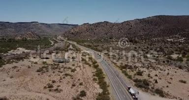 惊人的电影空中拍摄，车辆行驶在阳光明媚的沙漠丘陵。美国风景优美的公路旅行探险