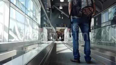 一个背着背包的年轻人的特写镜头使用机场走道穿过机场坐在飞机上。