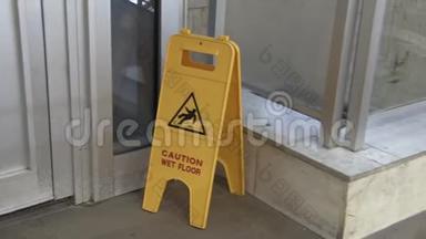 显示湿<strong>地板</strong>警告图标的<strong>标志</strong>。 站在混凝土表面的黄色招牌。 展览厅警告通告