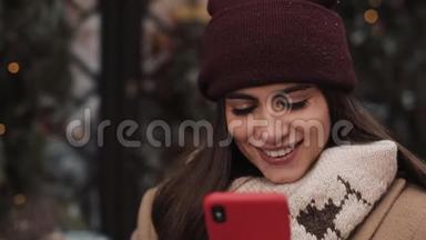 冬帽微笑<strong>女孩</strong>的特写和<strong>社交网络</strong>中的手套聊天，使用她的智能手机，看着