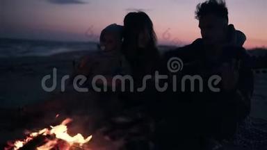 可爱，年轻的家庭和女儿一起在海滩上用火和吉他，家庭<strong>价值观</strong>的概念