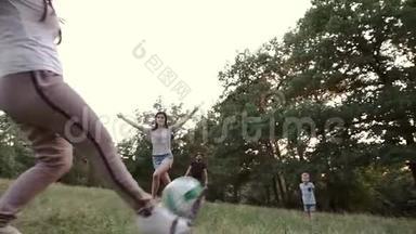 一个孩子和父母和<strong>家人朋友</strong>在森林空地上玩球。