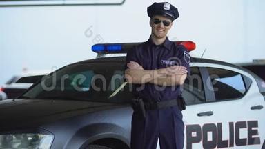 英俊的警官微笑着，站在新巡逻车附近，法律和秩序