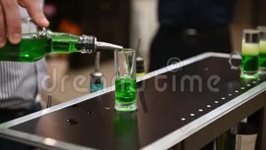 酒吧服务员正在酒吧或餐馆的酒吧里准备一杯绿色墨西哥鸡尾酒。 夜生活