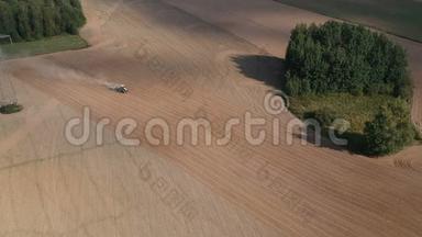农业工业。 拖拉机在夏末培育收获的田地，空中