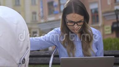 忙碌的女人一边在笔记本电脑上喂婴儿，单身母亲的艰难生活