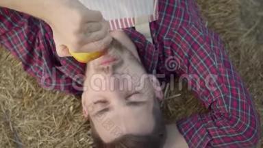 大胡子的年轻人躺在干草上吃新鲜的苹果。 农夫下班后休息。 乡村生活方式，乡<strong>村风</strong>格..
