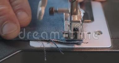 `缝纫机上用牛仔牛仔裤进行手工缝制。 牛仔服装、汉明牛仔裤、手工服装