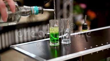 酒吧服务员正在酒吧或餐馆的酒吧里准备一杯绿色墨西哥鸡尾酒。 夜生活