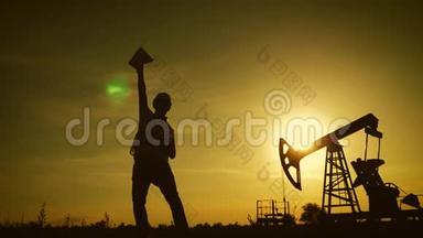 金色夕阳下油田原油泵幸福油田工人剪报。 工业、油田、人民和