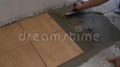 师傅手把瓷砖水泥胶放在地板上.. 家庭改造