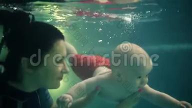 布鲁内特妈妈带着小儿子潜入水下，在游泳池里玩得很开心。 健康的生活方式，活跃的家长，游泳