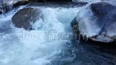 霜冻期间的暴风雨河。 在水中的大巨石上的冰柱。 水的快速<strong>电流</strong>.. 秋天，冬天，春天