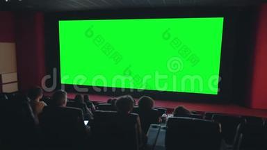 观看者在黑暗影院的绿色大屏幕共用空间欣赏电影
