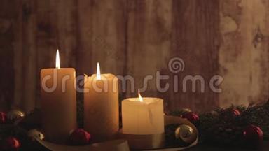 圣诞节的背景是点燃的蜡烛，带着移动的火焰，<strong>松</strong>枝</strong>，天然<strong>松</strong>果，红色和金色的，缎带装饰
