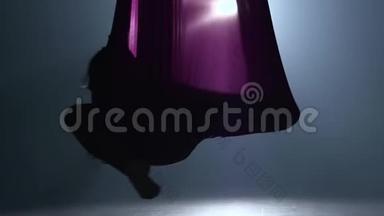 女子空中体操运动员在马戏团舞台上表演紫罗兰丝绸。 精彩的杂技表演.. 慢动作。 特写镜头。 303