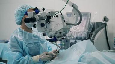 外科医生正在通过医疗设备观察眼部手术。 眼科医院的眼科医生。