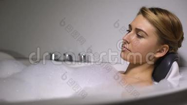 沮丧的女人躺在泡沫泡浴中，<strong>缓解</strong>压力，解决生活问题