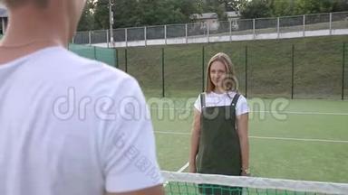 一个男人在网球比<strong>赛前</strong>接近一个女孩握手