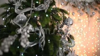 圣诞树上装饰着闪闪发光的圣诞树玩具和闪亮的灯光。 离焦物体