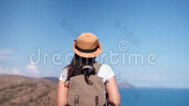 后景活动背包客女人欣赏美丽的海景，接近山顶