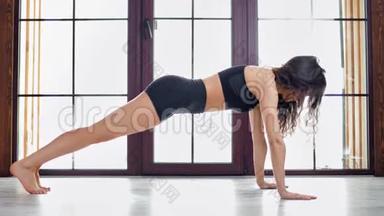 体育运动年轻的卷发女子在体操工作室的<strong>垫子</strong>上做俯卧撑锻炼