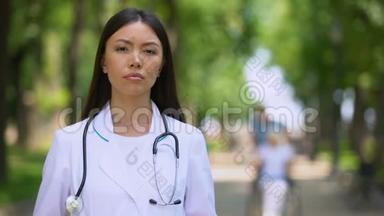 一位严肃的女医生在康复中心公园看镜头