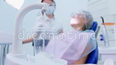 根据医生和病人的背景，在<strong>口腔诊所</strong>的玻璃中浇水。