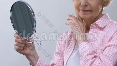 年老的女人照镜子，摸着<strong>皱纹</strong>的脸，想着失<strong>去</strong>的美丽