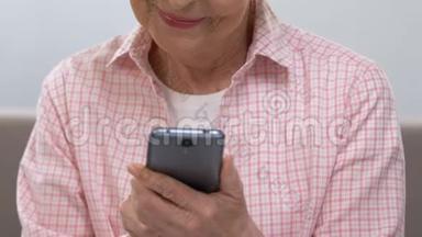 快乐的老妇人在智能手机上<strong>滚动</strong>，看家庭<strong>照片</strong>，特写