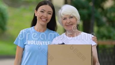 <strong>志愿者</strong>抱着老妇人拿着盒子，带着衣<strong>服</strong>，社会支持，捐款