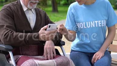 女志愿者教<strong>坐轮椅的老人</strong>如何使用手机