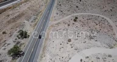 在美国亚利桑那州令人惊奇的夏天，Drone沿着银色的汽车沿着华丽的沙漠道路行驶。 路出行的出行理念..