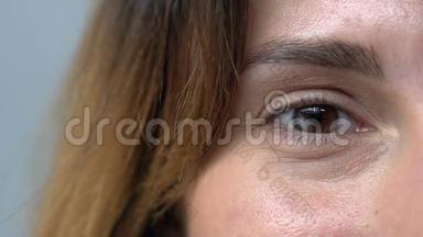 棕色眼睛的女人对着镜头微笑，模仿年龄皱纹和皮肤问题
