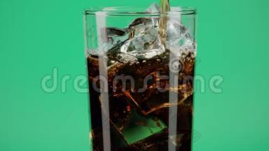 将可乐软饮料倒入杯中，在绿色背景下加入冰块，在红色动作拍摄红色