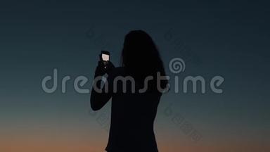 女孩在日落时拍照