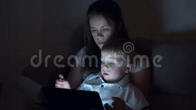妈妈带着小儿子躺在床上，晚上用数码平板电脑<strong>读故事</strong>。