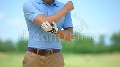 手套中的高尔夫球手在比赛前受到肘部紧张、按摩和热身的影响