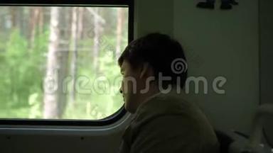 那家伙坐着火车，看着窗外，看着窗外移动的物体。 与家人一起旅行