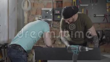 两个人在一个带工具的小作坊里工作。 两个木工用她的工具制作木片。 手的概念